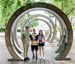 Will, Matt, Skylar stand under architectural circles on 4th street 